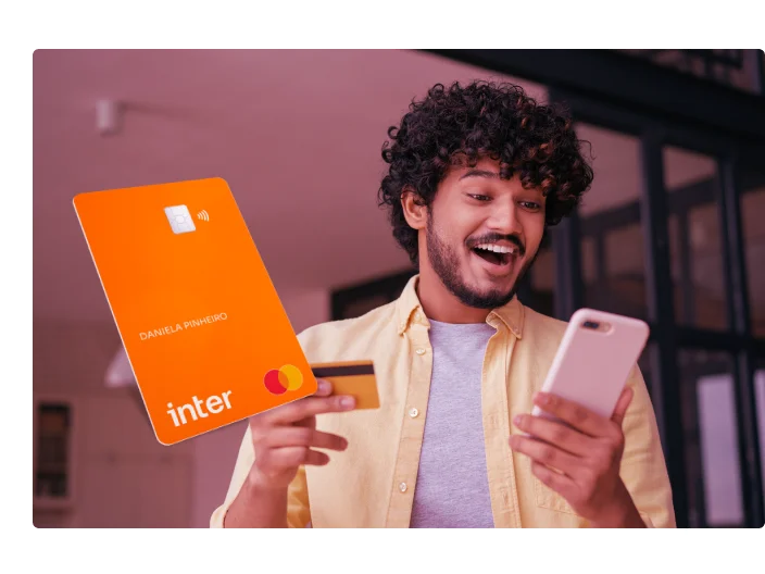 Homem indiano segurando cartão de crédito usando compras de celular on-line. Freelancer feliz receber pagamento, cheque saldo do cartão. Cara emocional pedindo comida on-line olhando para a tela digital