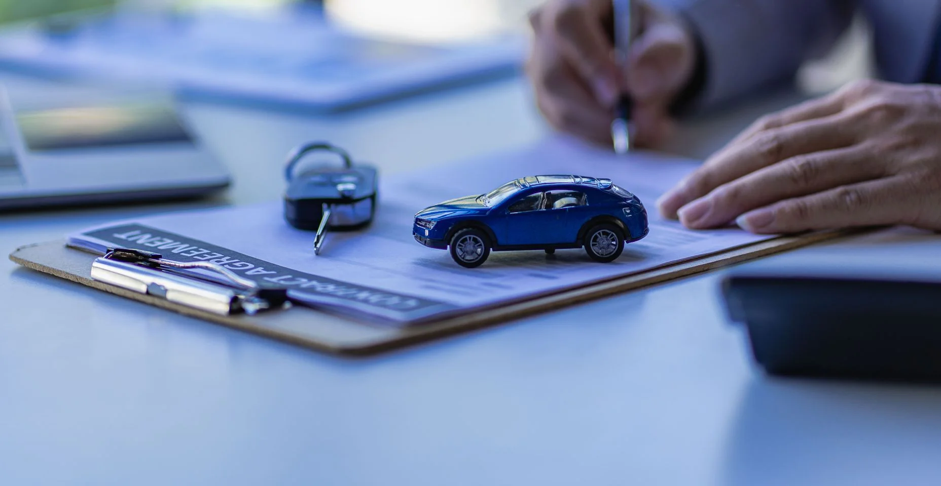 Conceito de vendas de carros, representantes de vendas dão chaves aos clientes na mesa com amostras de carros pequenos e seguro de escritório.