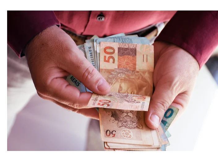 pessoa com dinheiro na mão representando a especulação financeira