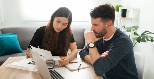 Casal estressado verificando suas contas e dívidas