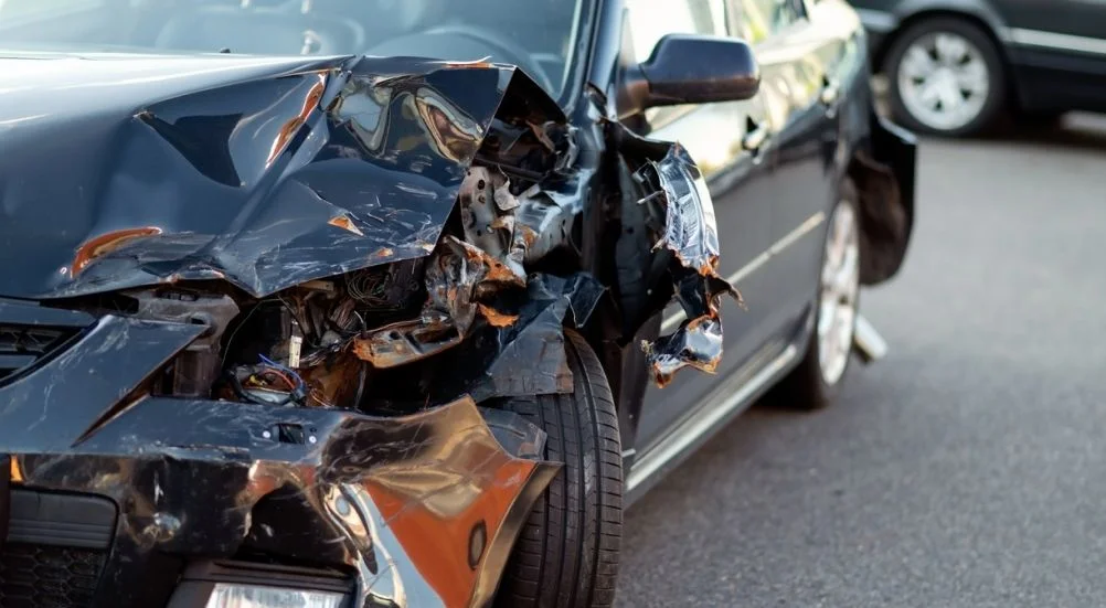 lose-up da peça danificada do carro após o acidente mostrando metal quebrado e arranhões