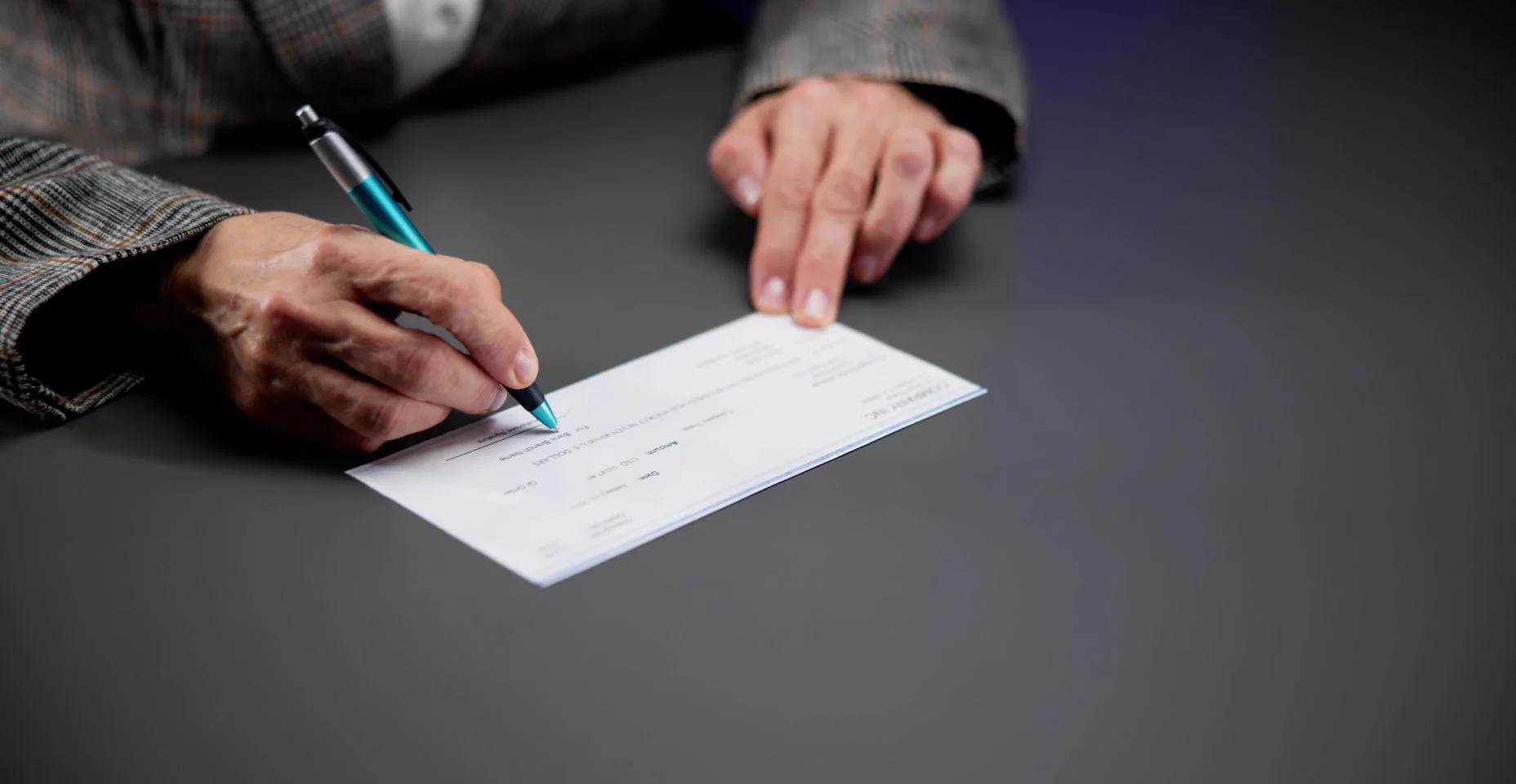 Mulher escrevendo um cheque, assinando um cheque