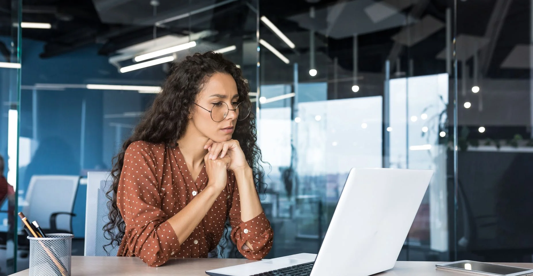 Pensativa e focada desenvolvedora web programador feminina trabalhando na empresa de desenvolvimento de produtos modernos Mulher hispânica sentada e pensando usando laptop para escrever código