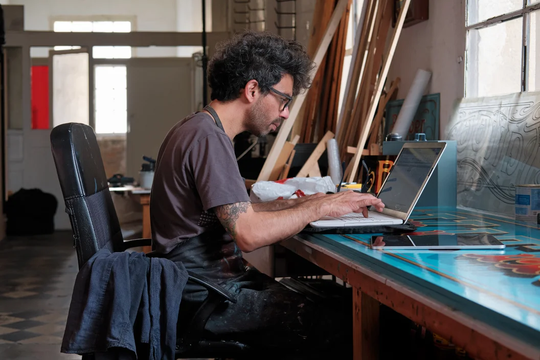 Um designer gráfico trabalha com um computador em um estúdio.