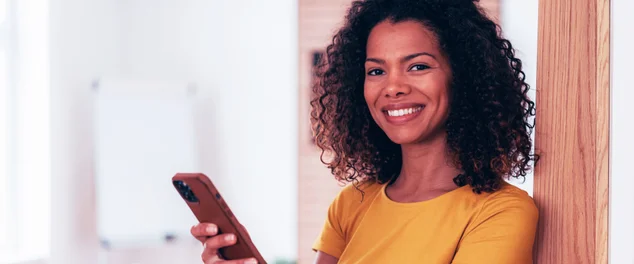 mulher sorrindo com um celular na mão