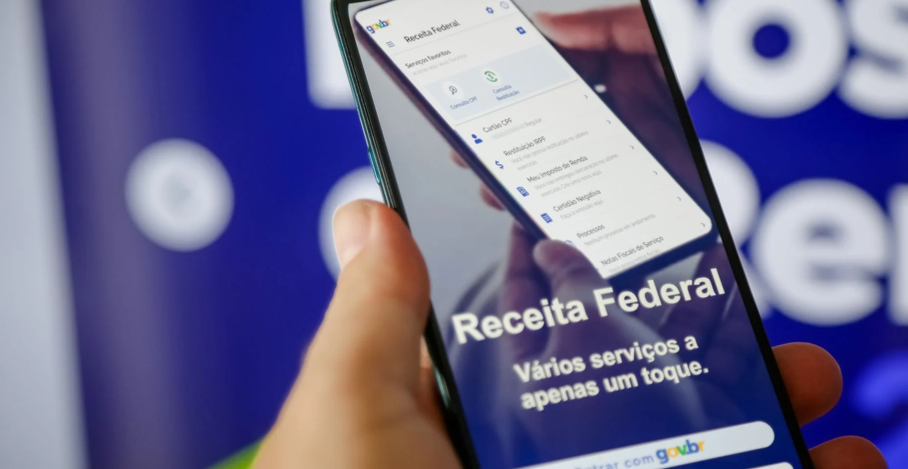 Imposto de renda 2024 da receita federal segurando celular com aplicativo e dinheiro