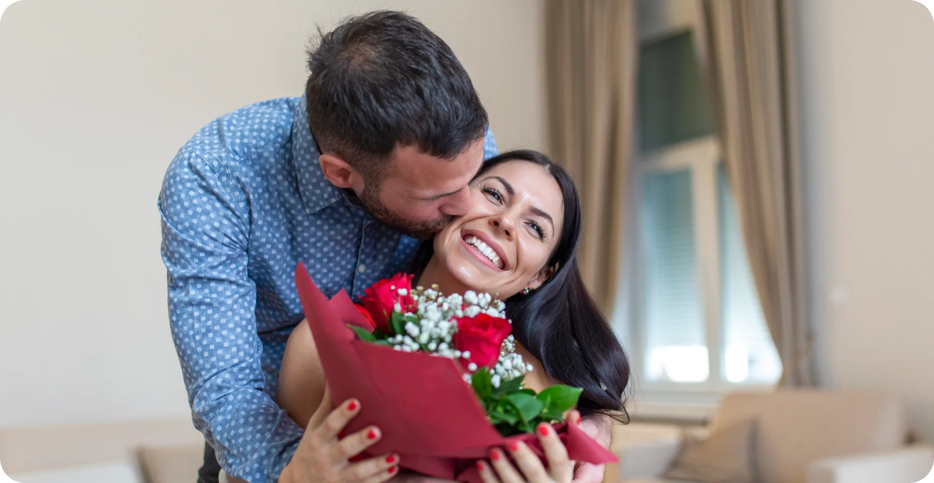 Jovem animada recebendo buquê inesperado de rosas vermelhas do marido em casa, Dia dos Namorados