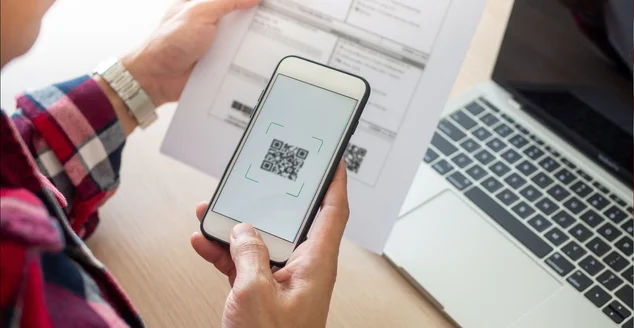 usando um celular para escanear o código QR da conta pelo aplicativo.