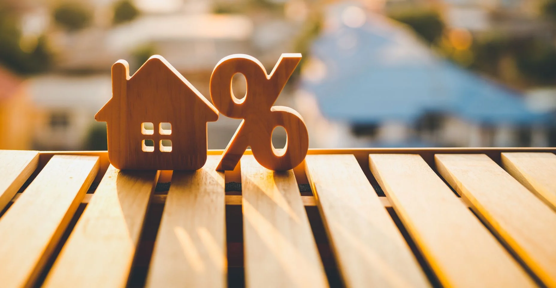 Porcentagem e ícone do símbolo do sinal da casa de madeira na mesa de madeira. Conceitos de juros imobiliários, imóveis, investimento em inflação.