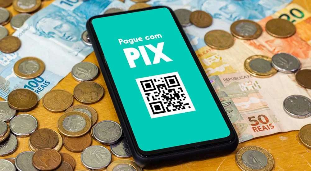 Pix na tela do smartphone com várias moedas ao redor. O Pix é o novo sistema de pagamento e transferência do governo brasileiro e brasileiro.