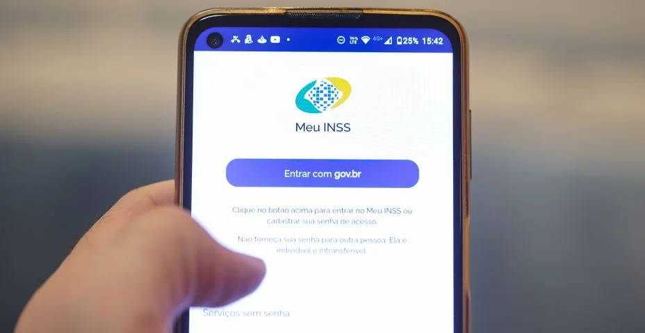 Instituto Nacional do Seguro Social na tela de um telefone celular que um homem está segurando. Aposentadoria, Benefícios, Brasil.