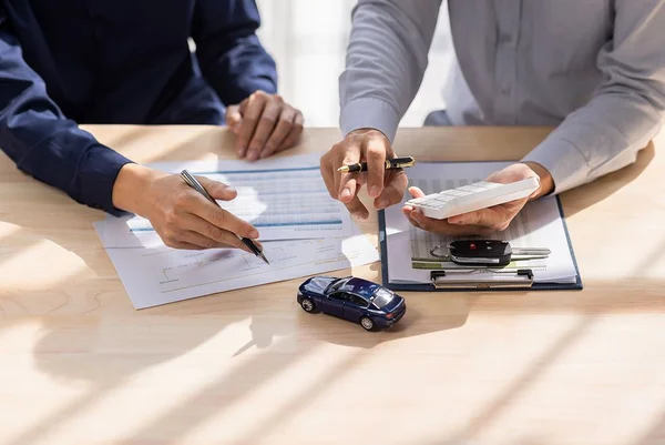 Vendedor do revendedor dando a chave do carro ao proprietário. cliente assinando documento de seguro ou contrato de contrato de contrato de locação de carro alugado Conceito de seguro de carro.
