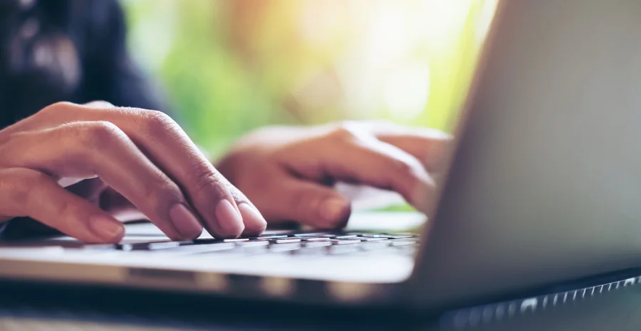 Closeup imagem das mãos de uma mulher de negócios trabalho e digitar no teclado do laptop na mesa de vidro