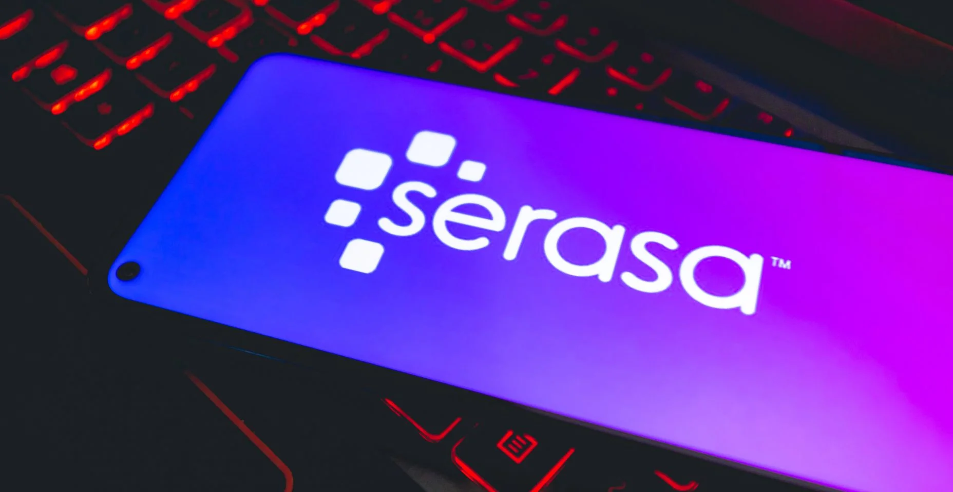 Um telefone celular com a logo da empresa brasileira Serasa sobre um teclado de notebook.