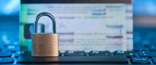 cadeado em cima do teclado, com um cartão de crédito no fundo desfocado