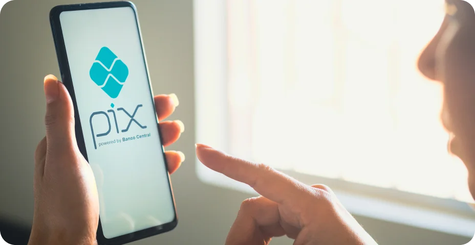 Brasil. Nesta ilustração fotográfica, uma mulher segura um smartphone com o logotipo do PIX exibido na tela.