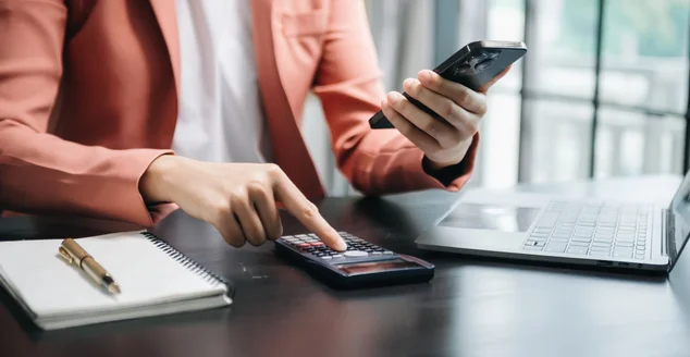 Empresário trabalha com finanças sobre custo e calculadora e laptop com tablet, smartphone no escritório à luz da manhã