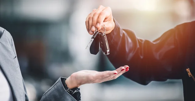 Closeup mão masculina dando uma chave de carro para empréstimo de veículo crédito financeiro, locação ou conceito de aluguel