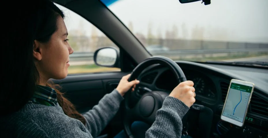 Mulher dirigindo o carro pela rodovia em tempo nublado