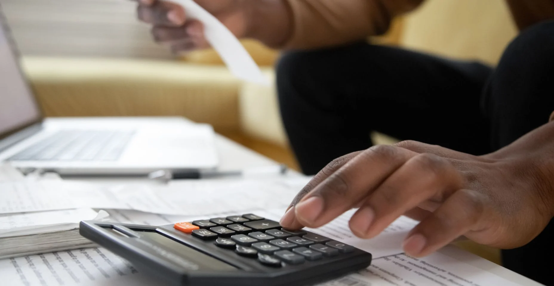 Close-up de homem afro-americano com calculadora verificando contas -