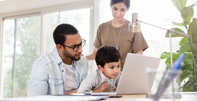 O garoto se concentra enquanto usa um laptop