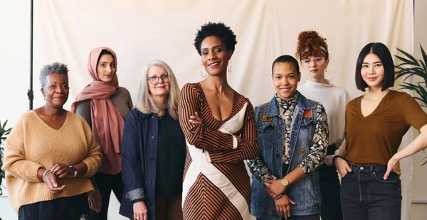 Retrato do Dia Internacional da Mulher de mulheres multiétnicas de faixa etária mista olhando com confiança para a câmera e sorrindo