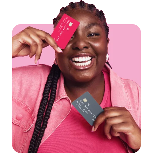 Mulher negra sorrindo segurando dois cartões de crédito.