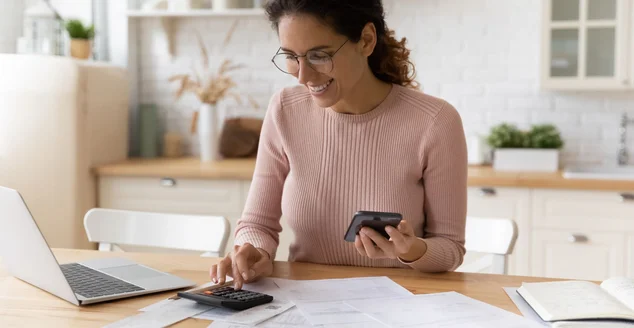 Trabalho feminino jovem latina com papéis financeiros contam com calculadora