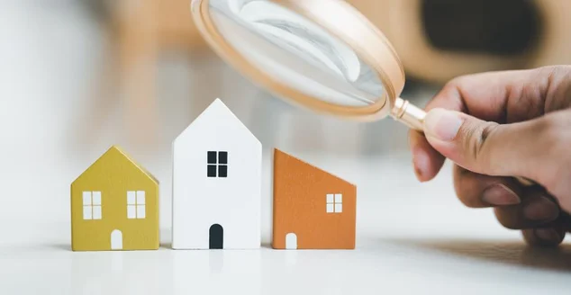 Lupa e modelo de casa, seleção de casas, conceito de imóveis.