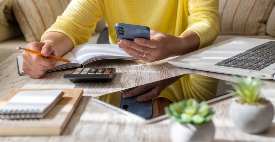 Mulher estabelecendo metas financeiras em casa.