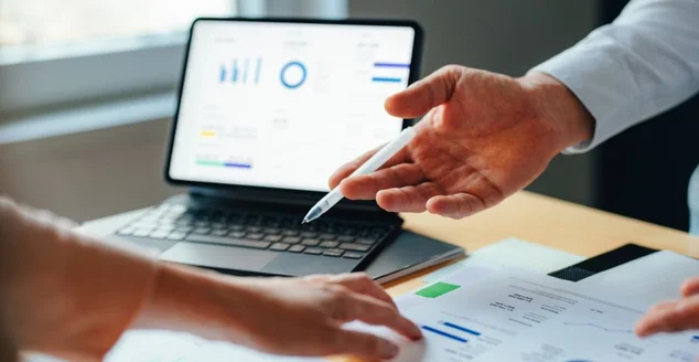 Empresários anônimos analisando gráficos e documentos de negócios juntos