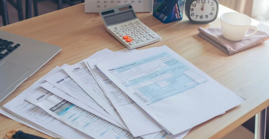 Formulário de Declaração de Imposto de Renda Pessoa Física, laptop e calculadora Para quem tem renda De acordo com a lei dos Estados Unidos, época que tem que pagar e prazo para pagamento de impostos. Planejamento De Orçamento e Conceito Tributário.