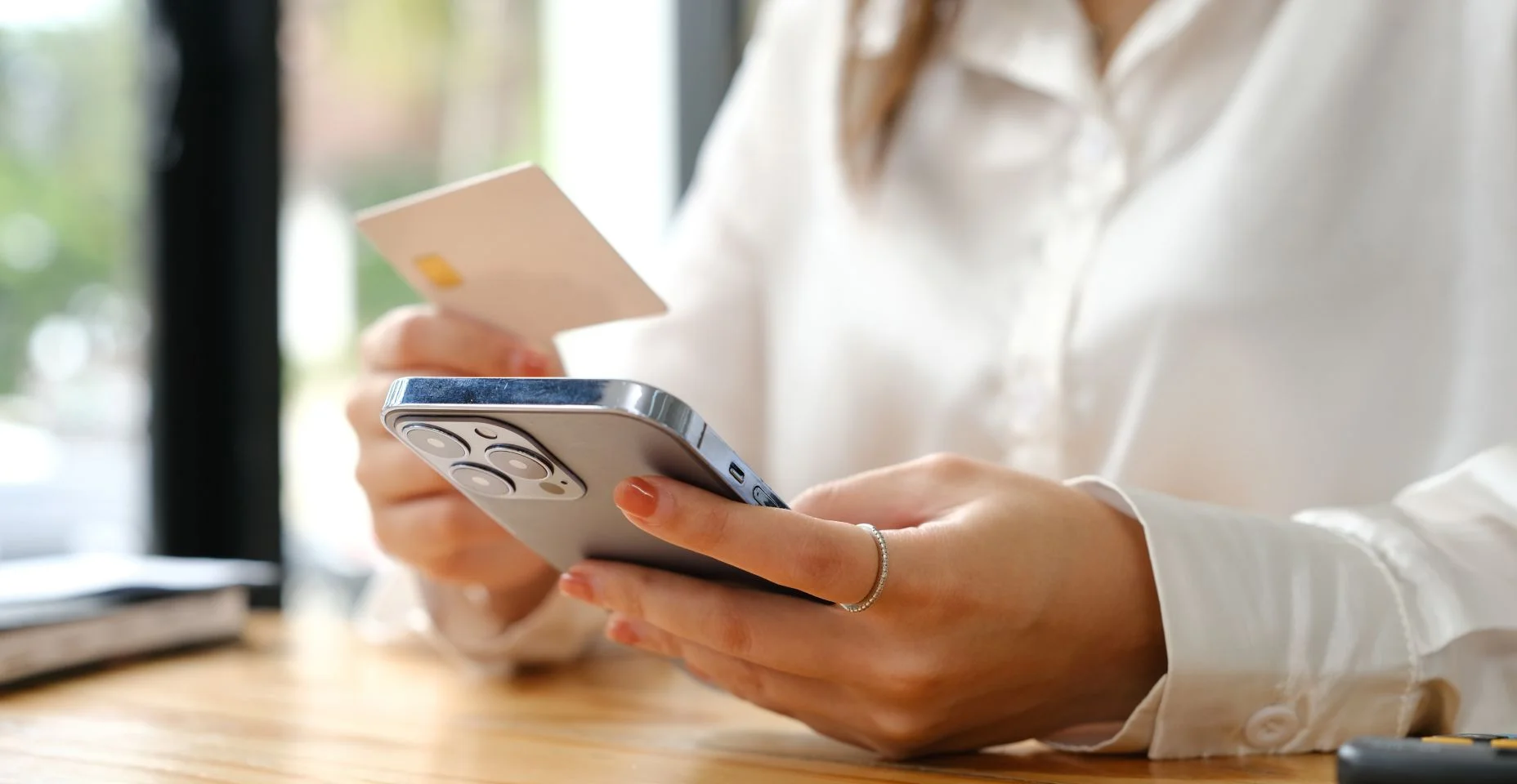 Mãos de mulher usando cartão de crédito para compras on-line