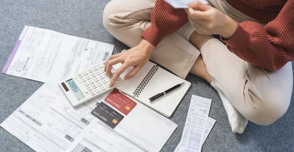 Conceito financeiro empresarial, jovem mulher asiática estressada, lista de verificação com conta para calcular despesa contábil, pagamento com cartão de crédito no prazo de vencimento, tentando encontrar dinheiro para pagar dívidas na mesa.