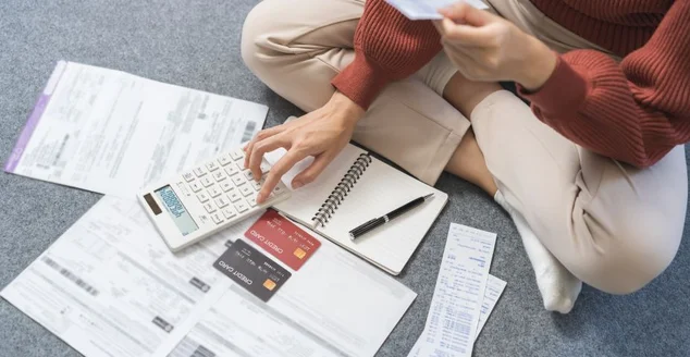 Conceito financeiro empresarial, jovem mulher asiática estressada, lista de verificação com conta para calcular despesa contábil, pagamento com cartão de crédito no prazo de vencimento, tentando encontrar dinheiro para pagar dívidas na mesa.