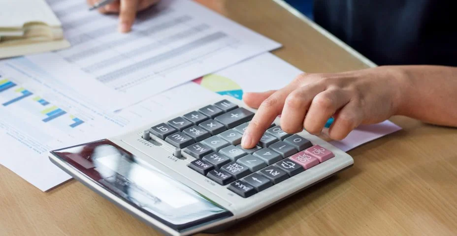 Midsection da mulher que calcula dados na mesa do escritório