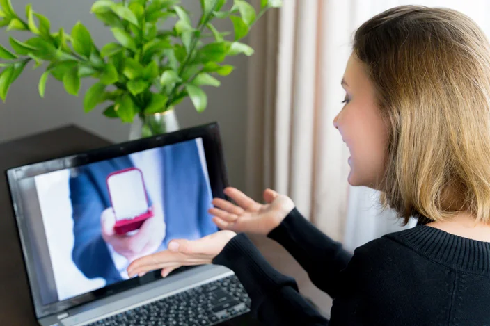 Chamada de vídeo online, pedido de casamento para namorada. Laptop, computador. Noivado, casamento. Anel de diamante na caixa vermelha. Você vai se casar comigo. Mulher surpresa e chocada diz que sim. Quarentena,coronavírus covid-19