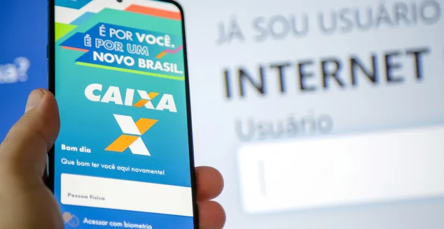 Aplicativo caixa federal num celular com uma pessoa segurando.