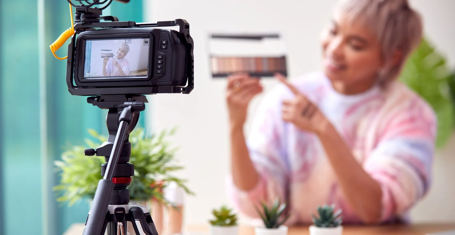 Vlogger feminino gravando beleza e maquiagem vídeo em casa com câmera