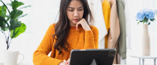 Mulher com expressão apreensiva pesquisando em um tablet quem não pode ser MEI