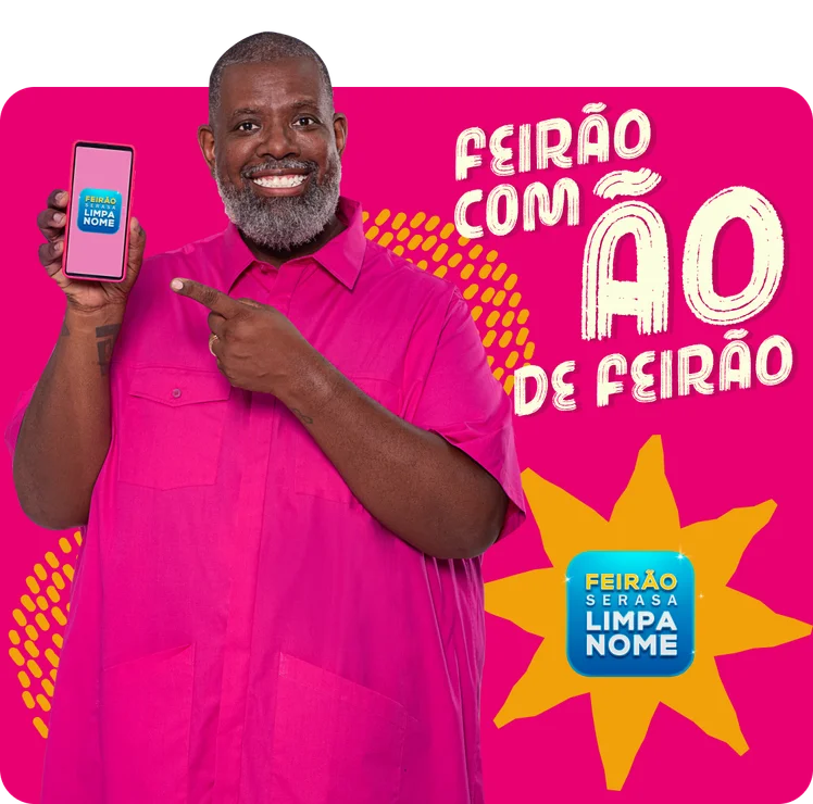 Homem negro sorrindo, vestindo uma blusa rosa e segurando o celular na mão com aplicativo Serasa