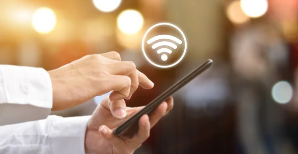 Mão de homem usando smartphone móvel com ícone wifi. Idéia para rede social de comunicação empresarial.