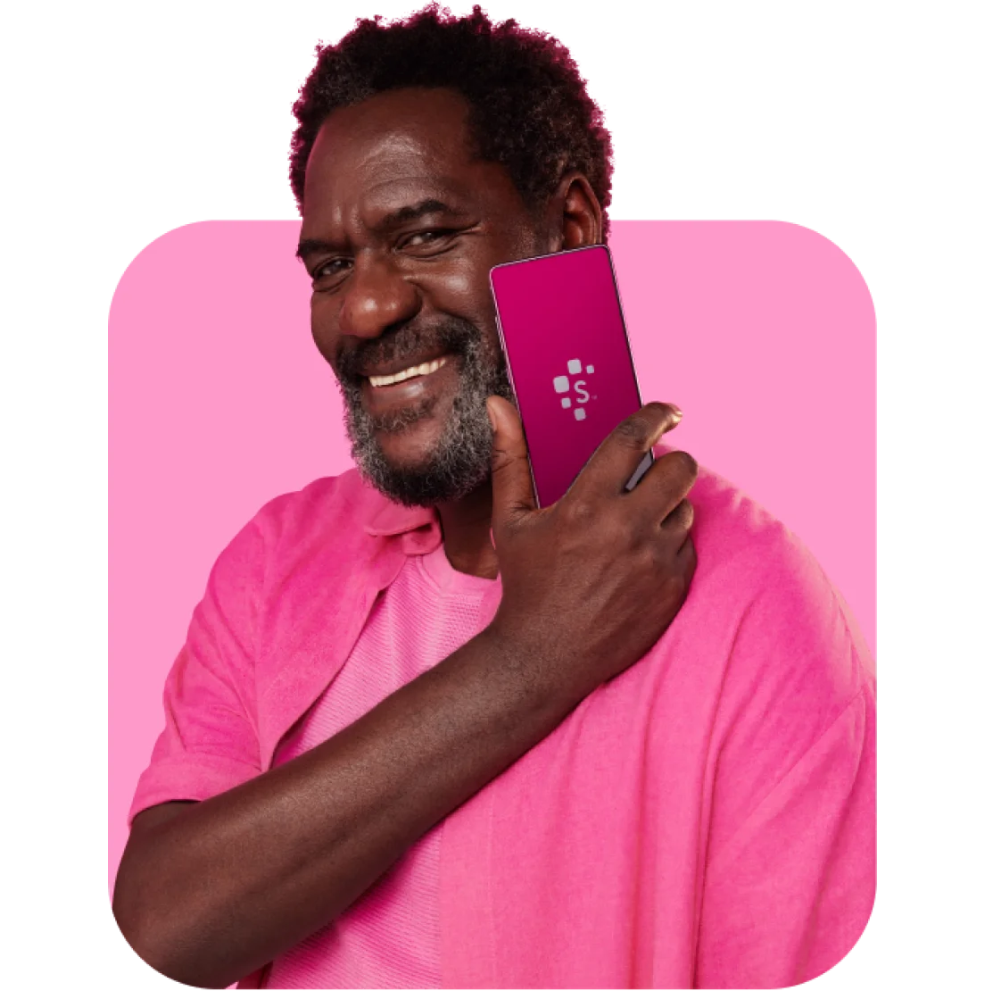 Homem negro sorrindo, vestindo uma blusa rosa e segurando o celular na mão com aplicativo Serasa