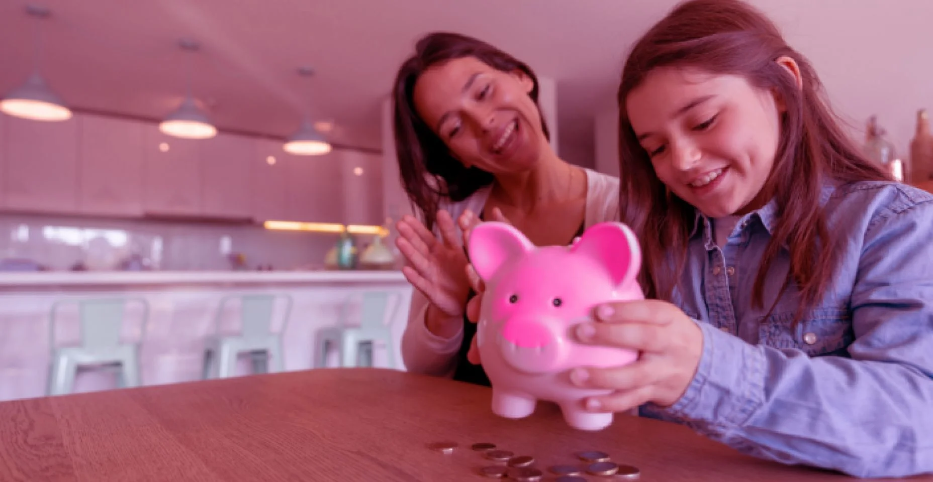 menina com a mãe segurando um porquinho de dinheiro
