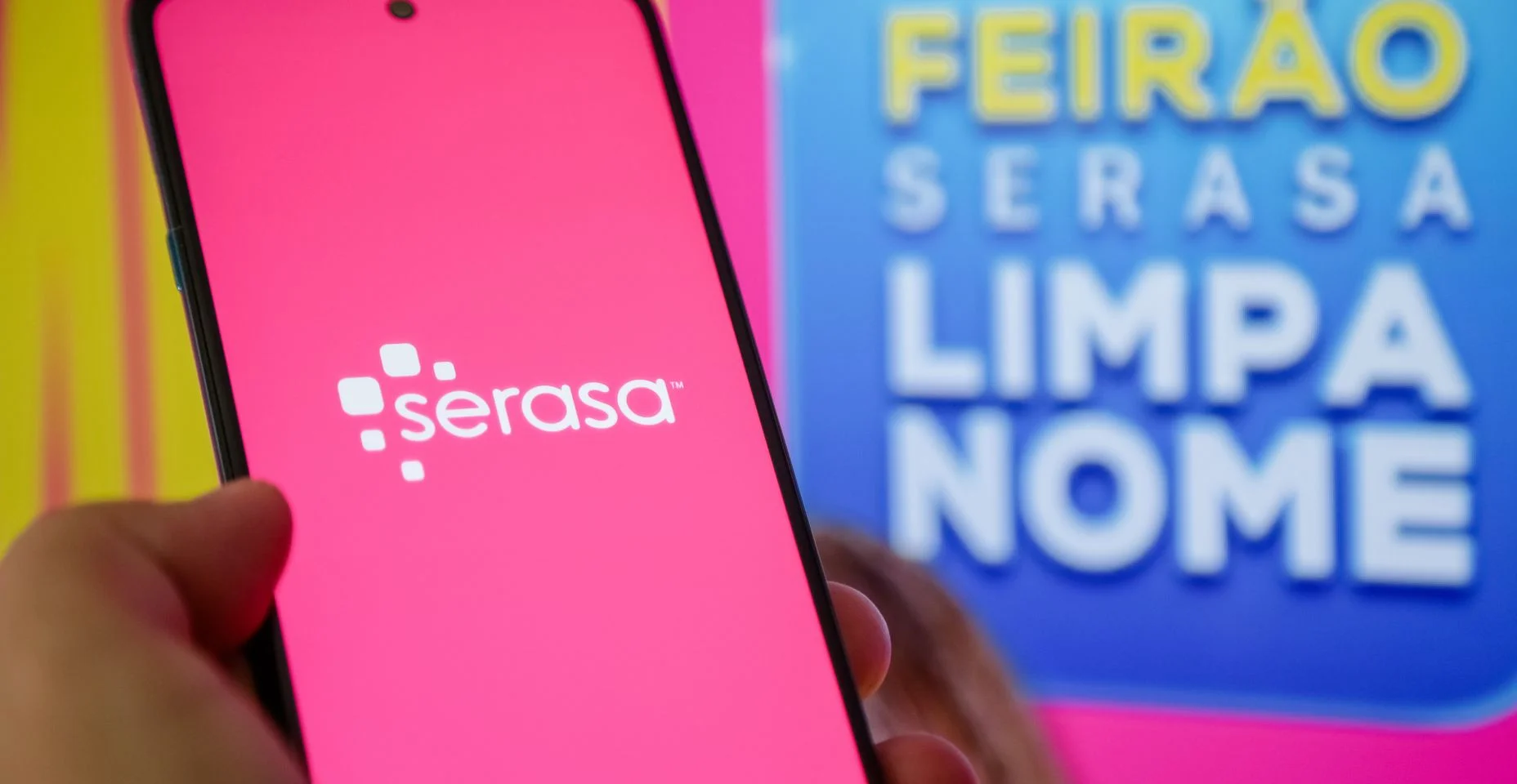 Aplicativo serasa na tela do celular na mão de uma pessoa.