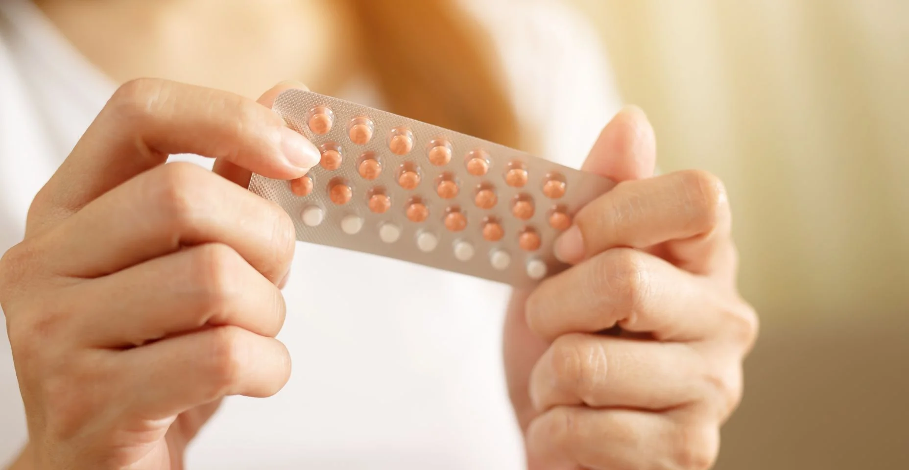 Mãos da mulher que abrem os comprimidos do controle de nascimento à disposicão. comendo pílula contraceptiva. A contracepção reduz o conceito do parto e da gravidez