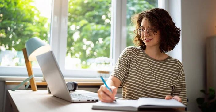 Mulher fazendo anotações em seu caderno