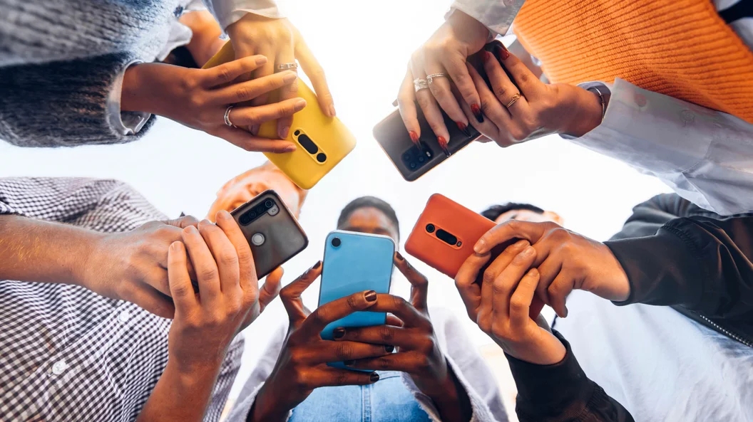Adolescentes em círculo segurando telefones celulares inteligentes - Jovens multiculturais usando celulares fora - Adolescentes viciados em novo conceito de tecnologia