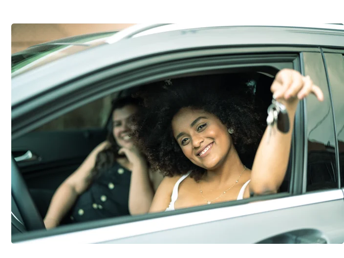 mulher dentro do carro pendurando a chave do carro para fora do carro