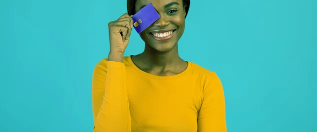 mulher sorrindo com cartão de credito na mão